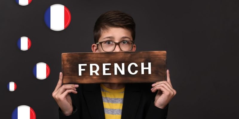 learning French. a teenager holds an advertising sign for language courses.