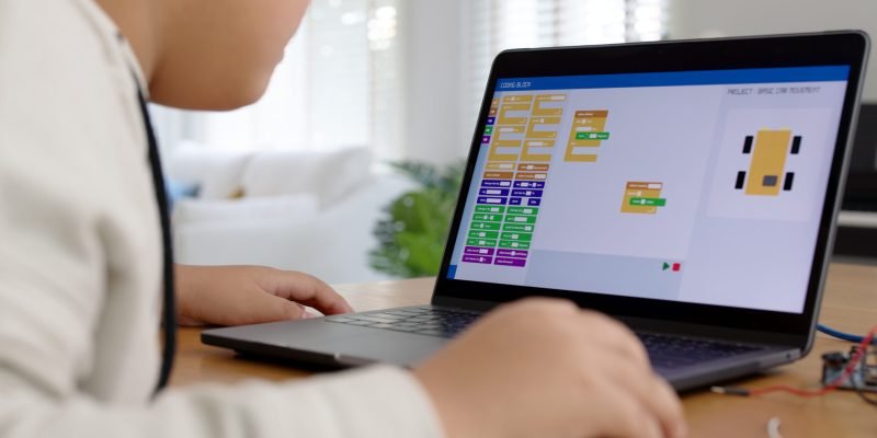 Young asia student remotely learn online at home in coding robot car and electronic board cable in STEM, STEAM, mathematics engineering science technology computer code in robotics for kids concept.