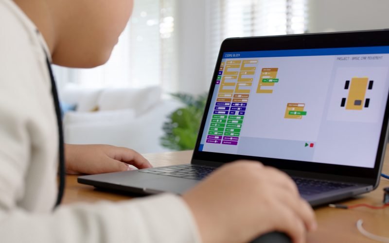 Young asia student remotely learn online at home in coding robot car and electronic board cable in STEM, STEAM, mathematics engineering science technology computer code in robotics for kids concept.