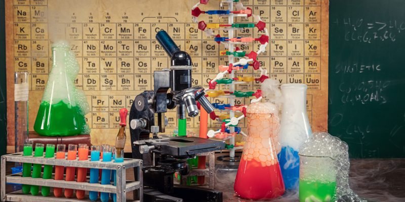Rapid chemical reaction in university lab with beakers. Chemistry classes with a microscope and a DNA model.