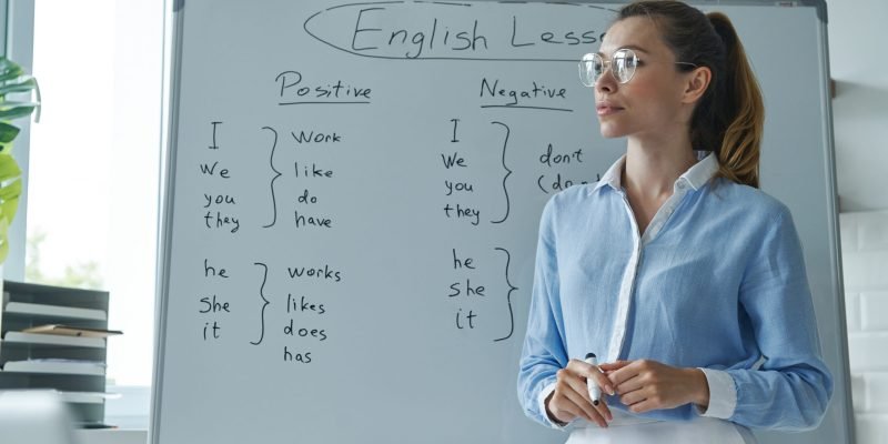 Thoughtful young woman standing near the whiteboard at the classroom